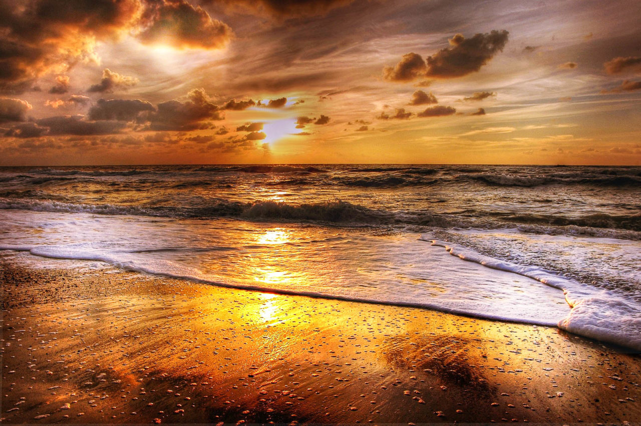 Strand, Meer, Brandung, Sonnenuntergang mit Wolken am Himmel