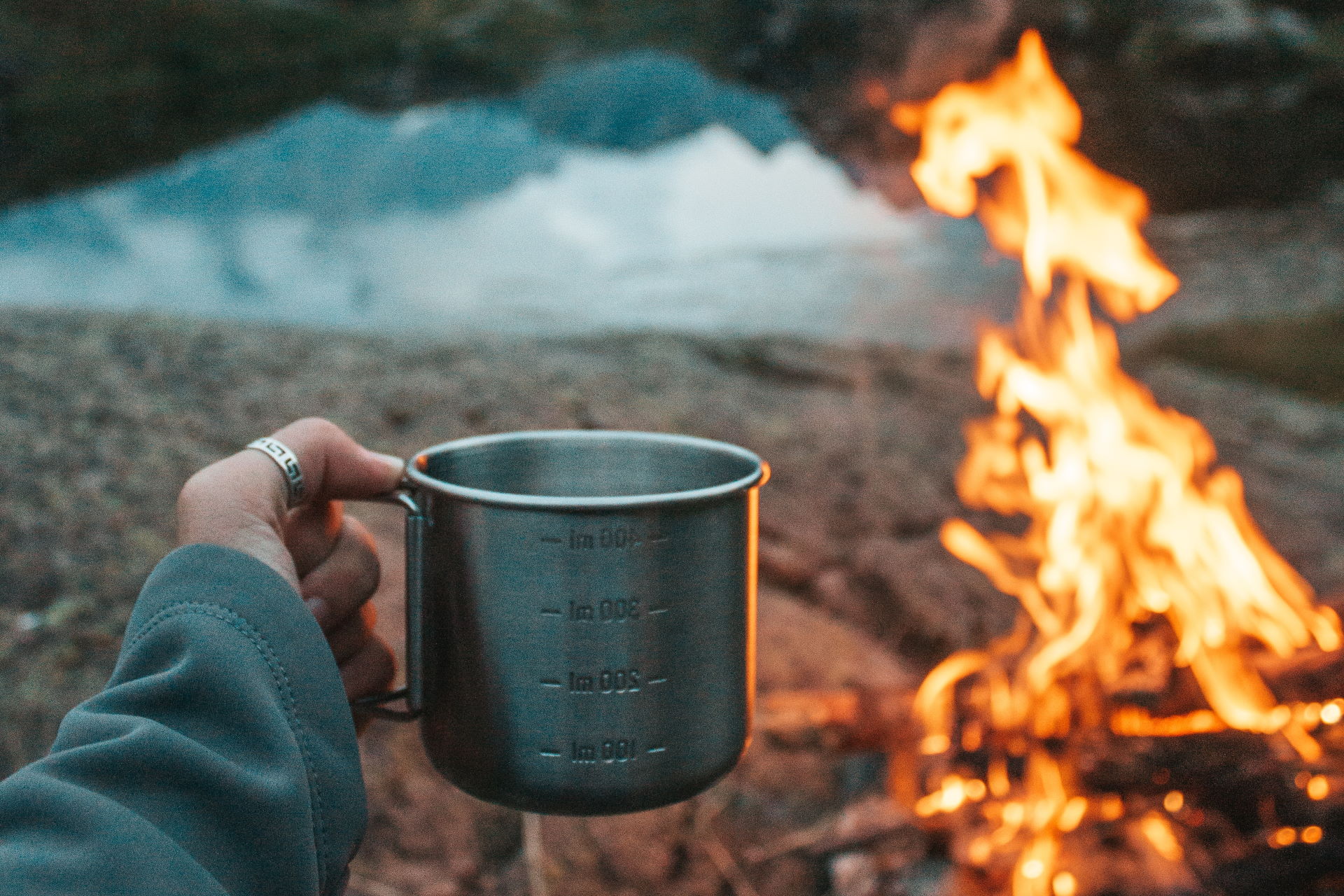 Am Lagerfeuer die Natur mit einer heißen Tasse Kaffee genießen