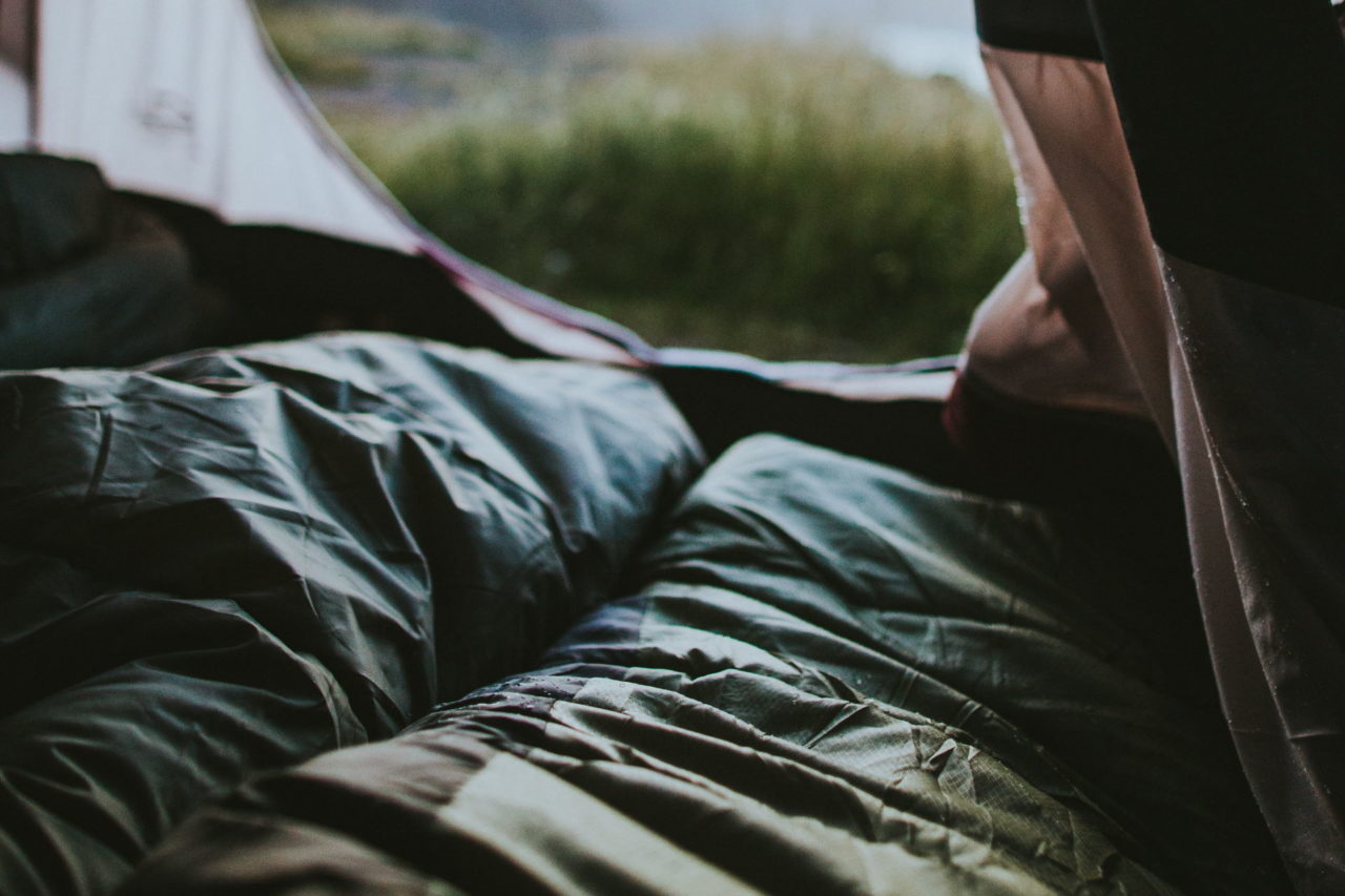 Schlafsäcke in einem offenen Zelt bei Regen