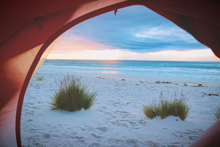 Blick aus einem-Zelt am Strand in den Sonnenaufgang