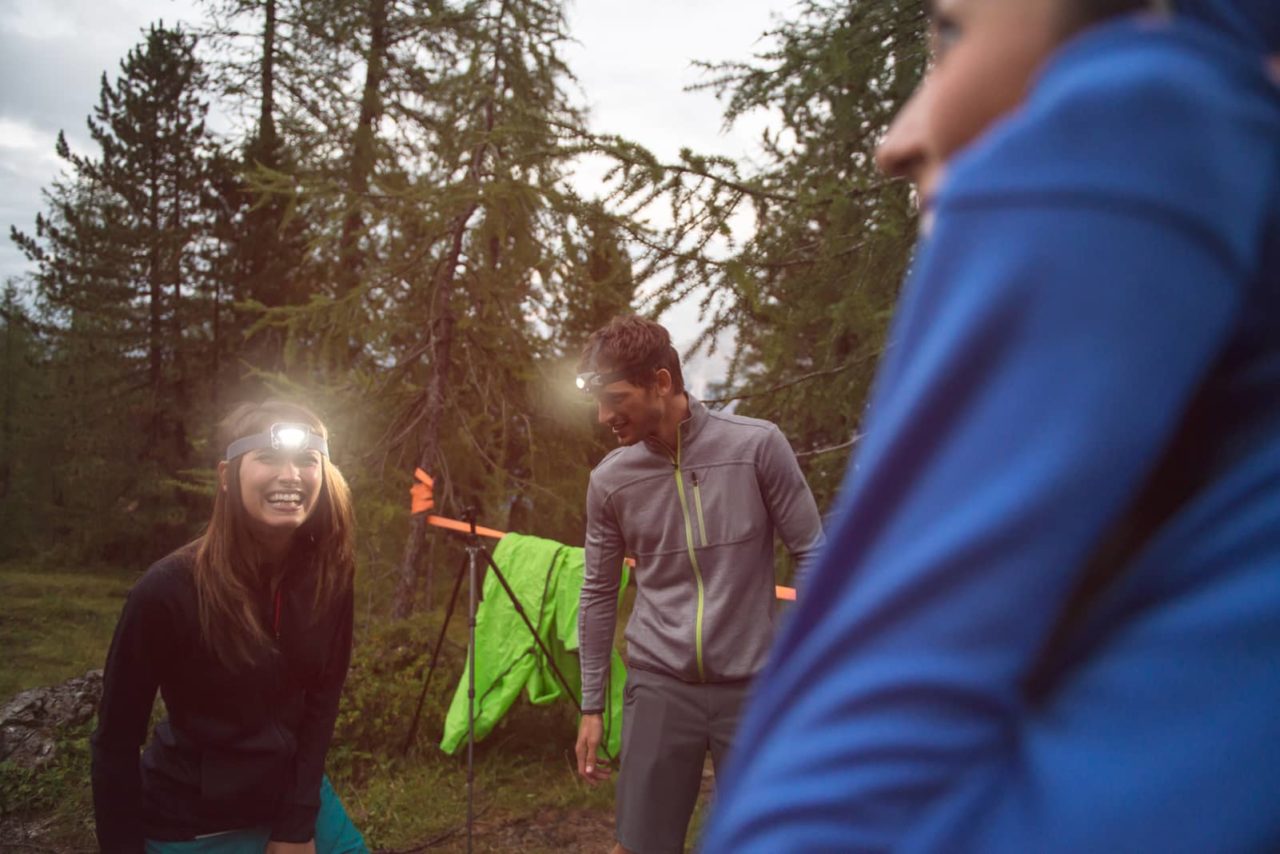 Frau und Mann mit Stirnlampe beim Camping
