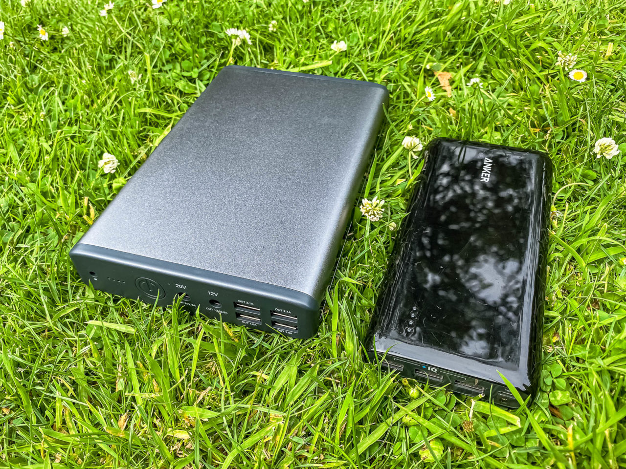 MaxOak K2 Notebook Power Bank Test - Größenvergleich mit Anker Powerbank, liegt im Gras