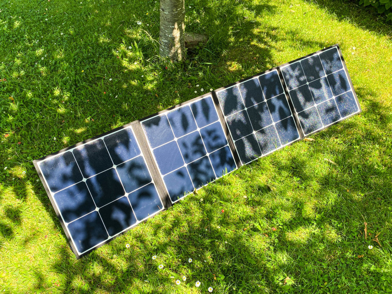 PowerOak Bluetti SP120 Solarpanel Test - Das Solarmodul steht entfaltet auf einer Wiese unter einem Baum im Halbschatten